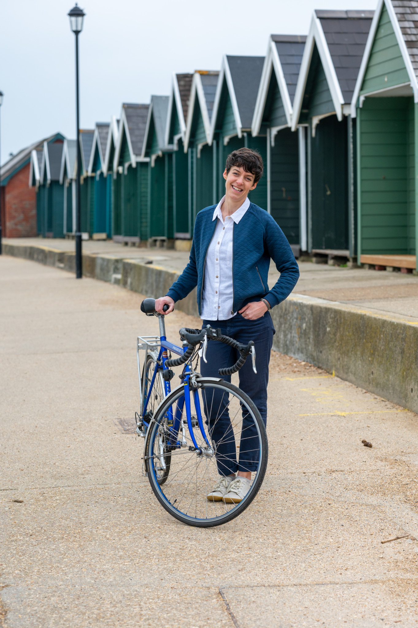 Bryony Rust standing with her bike next to beach houses